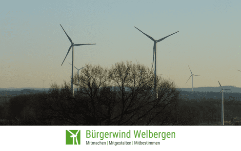 Windr&auml;der auf einem gr&uuml;nen Feld im Hintergrund, mit einem Baum im Vordergrund und einem Logo unten.